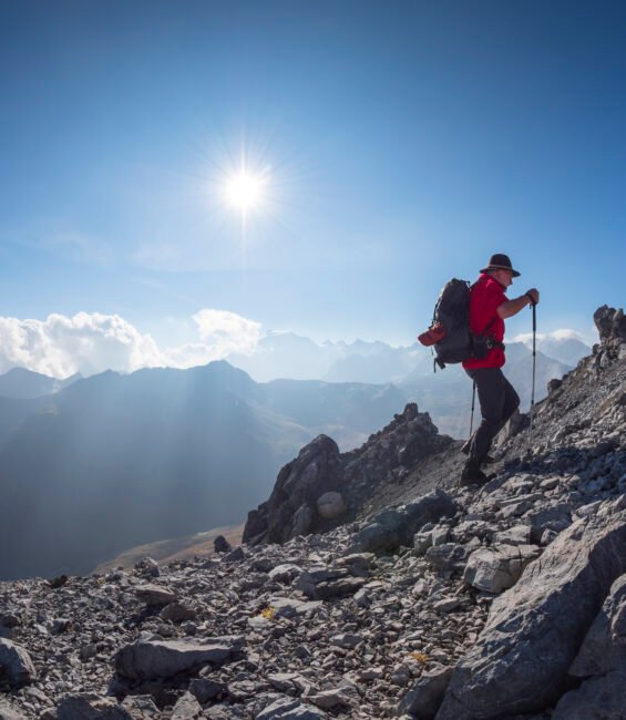 Border region Italy Switzerland, senior man hiking in mountain landscape at Piz Umbrail